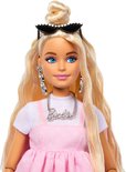 Close-up van Barbiepop met blonde staart, blauwe ogen, ketting met 'Barbie'-opschrift, grote oorbellen.