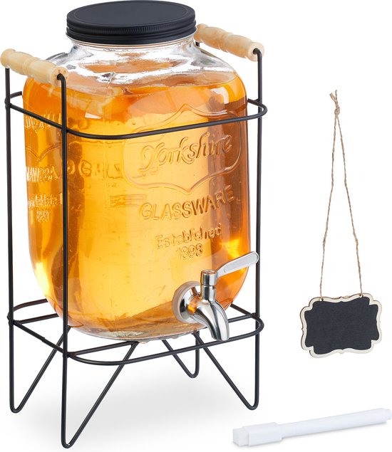 Glazen drankdispenser met oranje drank, metalen kraantje, standaard en een krijtbordje.