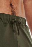 Detail van het trekkoord van een groene trainingsbroek.