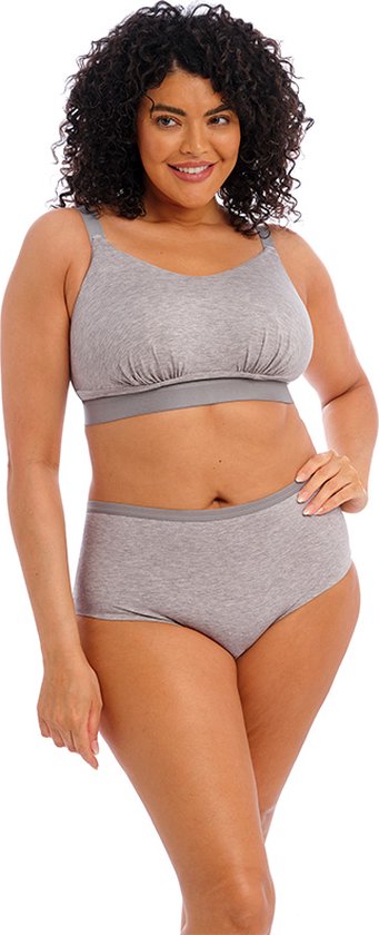 Model met krullend haar, lachend, draagt een grijze bralette en bijpassende grijze onderbroek met grijze bies.