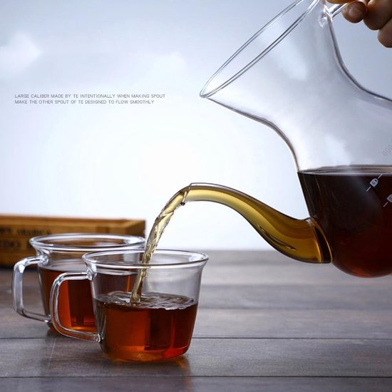 Glazen koffiekan schenkt koffie in twee glazen mokken.
