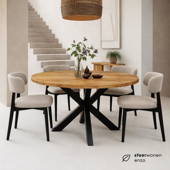 Ronde mangohouten eettafel met zwart stalen matrix onderstel, met vier stoelen eromheen.