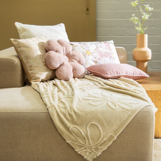 Bank met beige plaid met bloemendessin en verschillende sierkussens, waaronder roze.