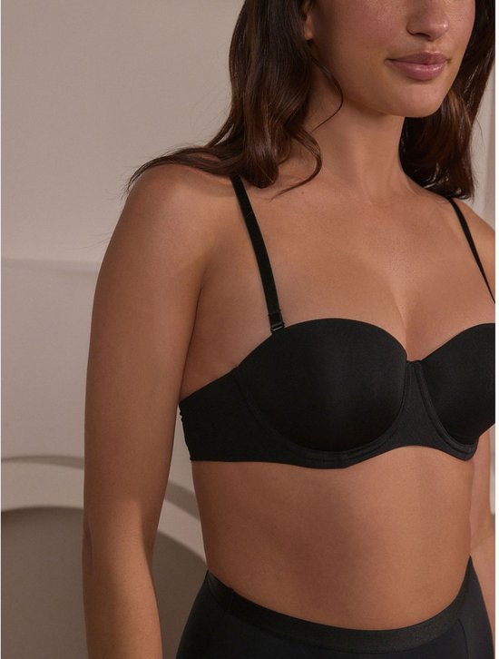 Model draagt zwarte push-up beha zonder bandjes.