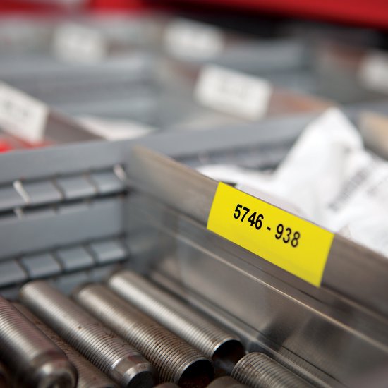 Gele sticker met zwarte tekst '5746 - 938' op een metalen bakje met schroeven.