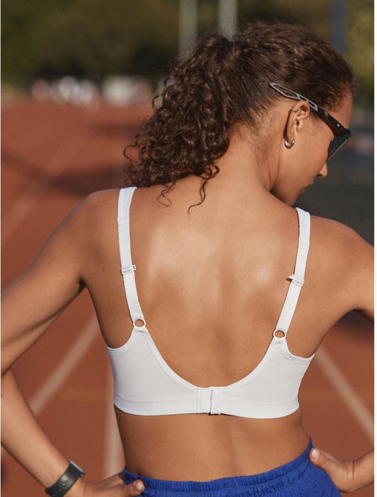 Een witte sportbeha met beugel en bandjes die op de rug samenkomen.