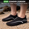 Zwarte Travelhawk waterschoenen met witte streep op strand.