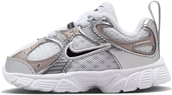 Kindersneaker van Nike in wit met zilveren en roségouden accenten, met zwarte swoosh.