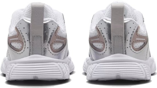 Achterkant van twee witte Nike kindersneakers met zilveren en roségouden details.