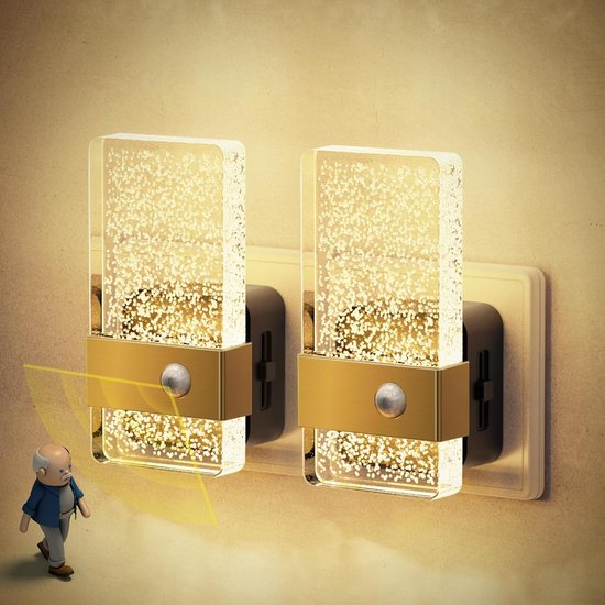 Twee gouden en glazen nachtlampjes met bewegingssensor aan de muur.