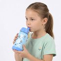Een jong meisje met een paardenstaart drinkt uit een lichtblauwe waterfles met Bluey-print.