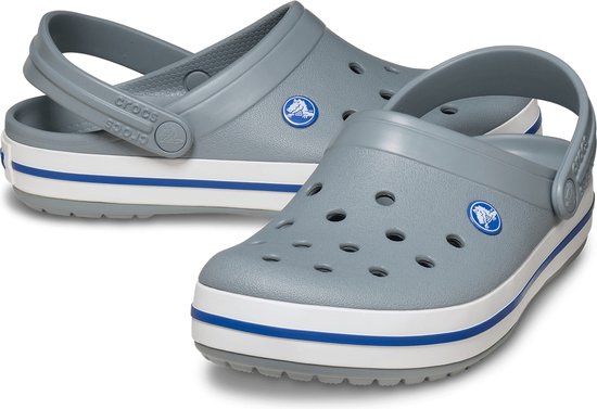 Grijze Crocs met witte en blauwe strepen op de zool.