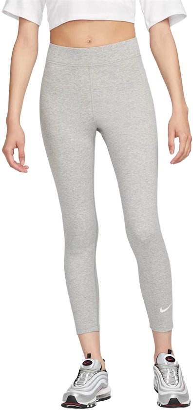 Een model draagt een lichtgrijze Nike legging met sneakers.