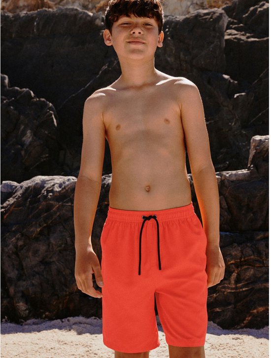 Jongen met oranje zwemshort, met trekkoord aan de voorkant.