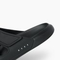 Close-up van de neus van een zwarte Reef slipper met een dikke zool en klittenbandsluiting.