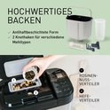 Zilverkleurige broodbakmachine met ingrediënten en toebehoren, zoals broodvorm en kneders.