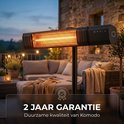 Zwarte staande infrarood terrasverwarmer met gloeiende elementen, op een terras met loungebank en tuinmeubilair.
