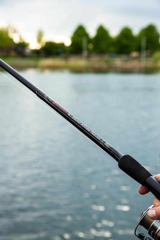 Hand houdt een 'Ultimate Allround Power Feeder' hengel vast boven water.