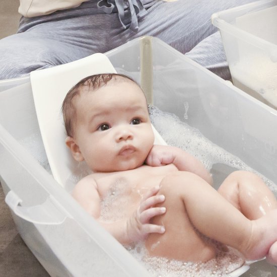 Baby ligt in een wit Stokke Flexi Bath badje met schuim.