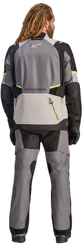Motorjas met Alpinestars-logo op de achterkant, grijze en zwarte panelen, met fluo-gele accenten.