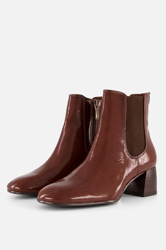Une paire de bottes courtes marron vernies avec talons blocs et côtés élastiques.
