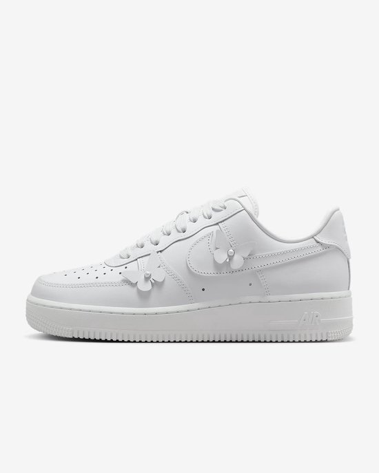 Zijaanzicht van een witte Nike Air Force 1 sneaker met vetersluiting, vlinderdetails en parels.