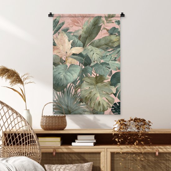 Wandkleed met tropische bladeren in groen en roze tinten, op een dressoir.