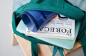 Tasse vert clair et objet bleu dans un sac.