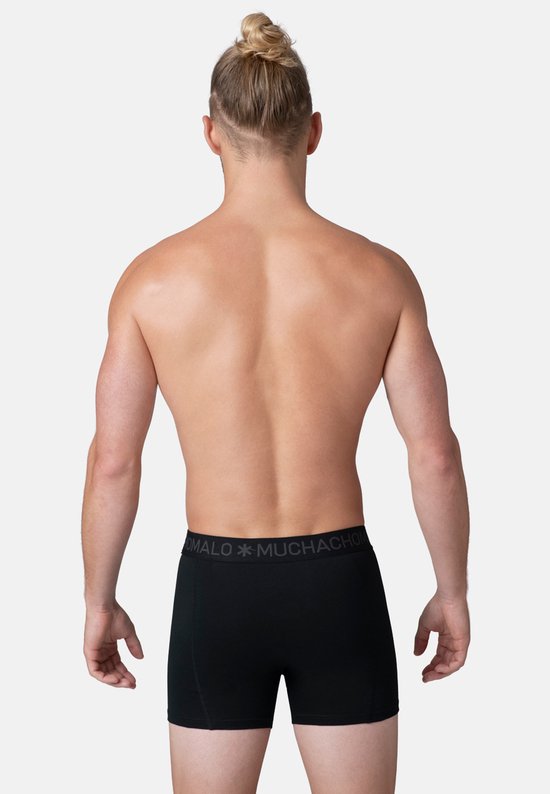Achterkant van een man met strakke rugspieren, draagt een zwarte Muchachomalo boxer.