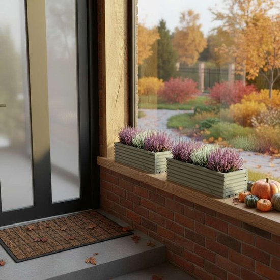 Twee grijze houten bloembakken met roze en witte heide, op een bakstenen vensterbank, met pompoenen en herfstbladeren.