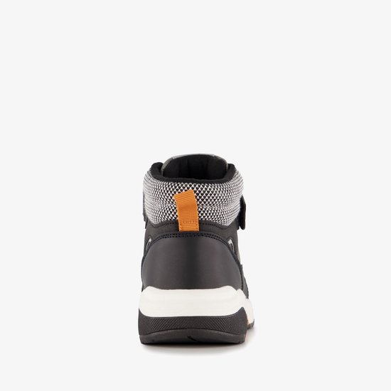 Achterkant van een grijze, bruine en witte hoge sneaker met oranje lusje.