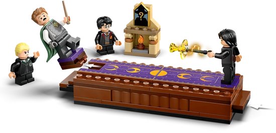 Deux figurines LEGO Harry Potter, une cheminée et un tapis de jeu à motifs violets et dorés.
