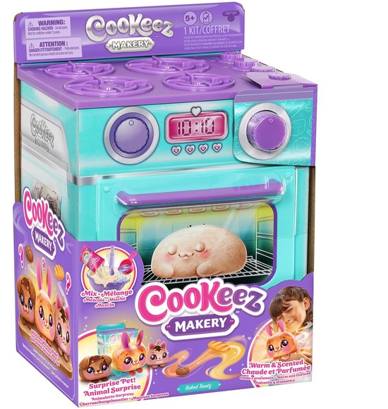 Paarse en turkooise speelgoedoven met "Cookeez Makery" logo. In de oven zit een broodvormig pluche figuur. De verpakking toont de stappen van het "Bak je pluchen knuffel" spel.