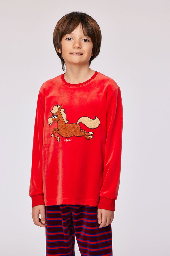 Jongen in een rode pyjamaset met ponyprint, staand met gezicht naar voren.