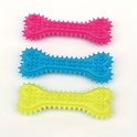 Drie botvormige kauwspeeltjes in roze, blauw en geel, met nopjes en stekels.