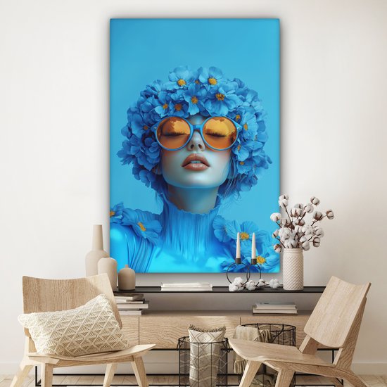 Portrait bleu d'une femme avec des lunettes orange et des fleurs, sur un mur avec des chaises.