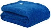 Een gevouwen blauwe teddy fleece deken, prachtig zacht met een label.