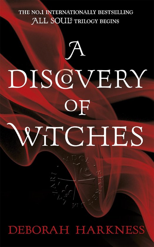 Couverture du livre 'A Discovery of Witches' avec du tissu rouge translucide et le titre en lettres blanches.