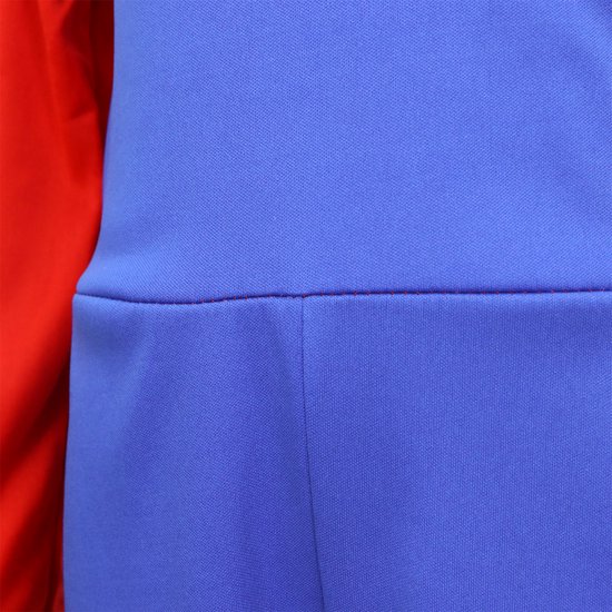 Detail van de naad van de blauwe tuinbroek op de rode top