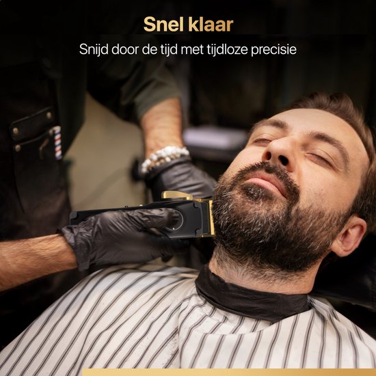 Barbier scheert de baard van een man met een zwarte tondeuse met gouden details, voor een snelle en precieze scheerbeurt.