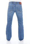 Achterkant van een man in een bootcut blauwe spijkerbroek met witte sneakers, met een bruin LTB leren label.