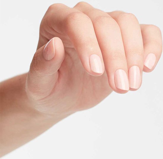 Hand met nagels gelakt in een zachtroze tint.