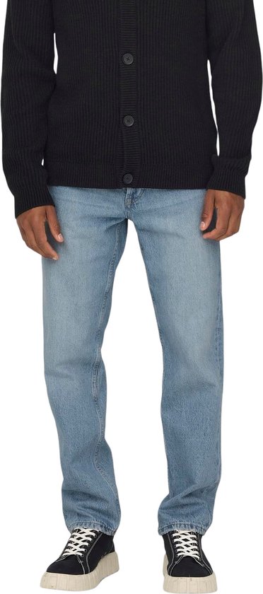Man met lichtblauwe jeans, gedetailleerde zakken en een bruin leren merklabel.