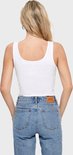 Achterkant van een witte, nauwsluitende tanktop met een ronde hals, gedragen met een spijkerbroek met bruin logo-label.