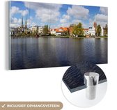MuchoWow® Glasschilderij 120x60 cm - Schilderij acrylglas - Uitzicht over de Duitse stad Lübeck - Foto op glas - Schilderijen