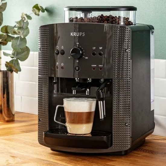 Krups volautomaat, antracietgrijs, met een kopje cappuccino.