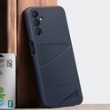 Donkerblauwe telefoonhoes met kaartvak, leunend tegen een houten object.