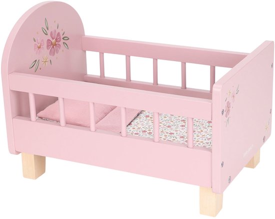 Leeg roze poppenbedje met bloemenmotief en houten pootjes.
