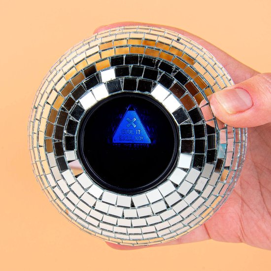 Hand houdt zilverkleurige discobal met spiegeltjes vast. Zwart scherm met blauwe tekst 'COOL IT BABE! NO!'.