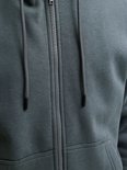 Close-up van de rits en het trekkoord van een donkergroene hoodie.